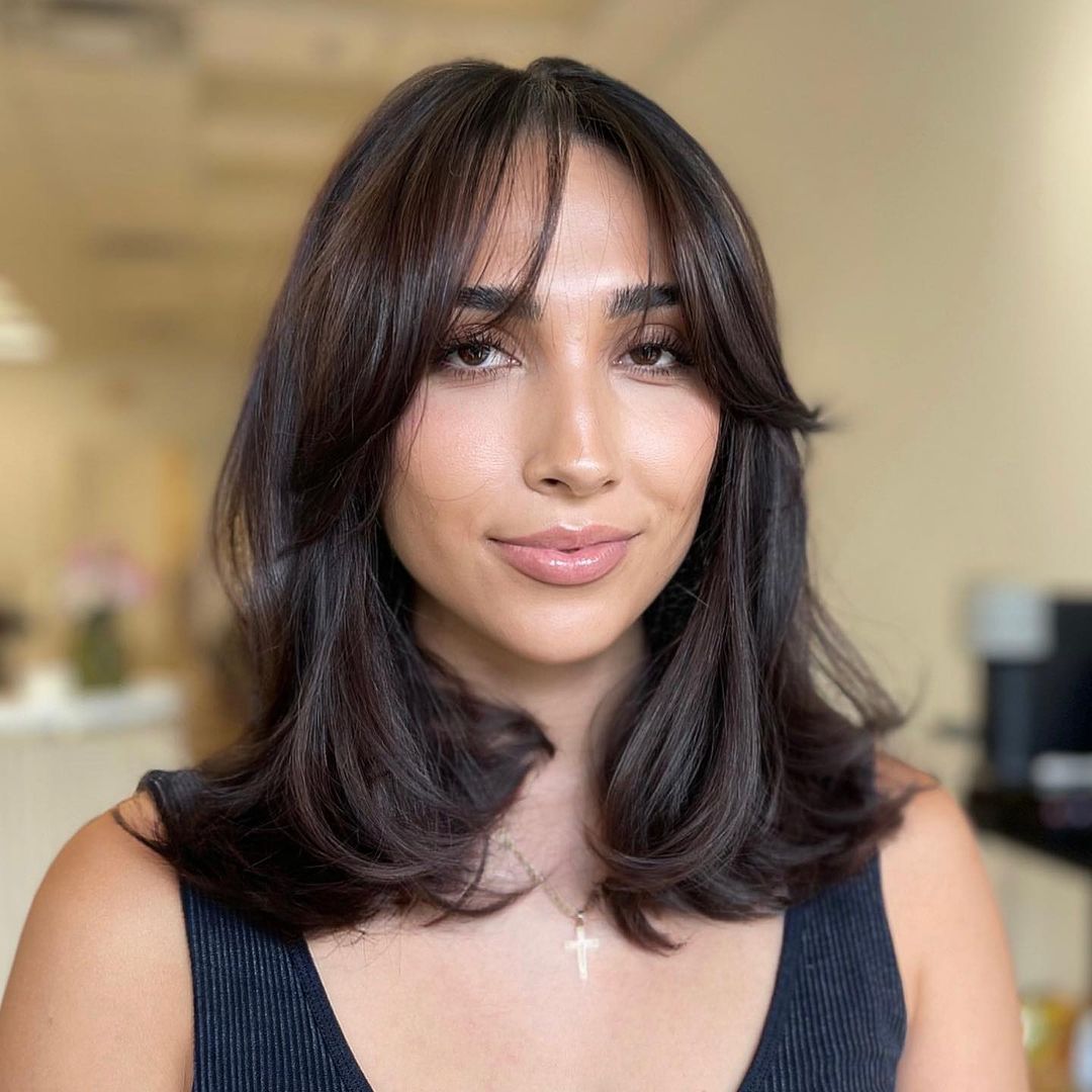 Medium Hairstyle with Soft Curtain Bangs and Bouncy Blowout